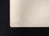 a white plate on a black table with a black background