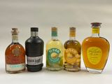 several bottles of liquor are lined up in a row on a white surface
