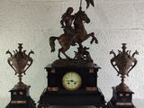 a statue of a man riding a horse next to three vases