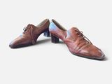 pair of brown leather shoes with laces on them on a white surface