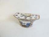 a small blue and white vase with holes in it