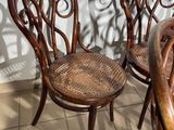 four wooden chairs and a table in a room