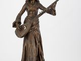 une statue en bronze représentant une femme jouant de la guitare sur un fond blanc