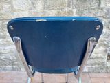 a blue chair sitting on top of a brick floor