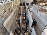 several wooden benches are lined up in a row on the side of the road