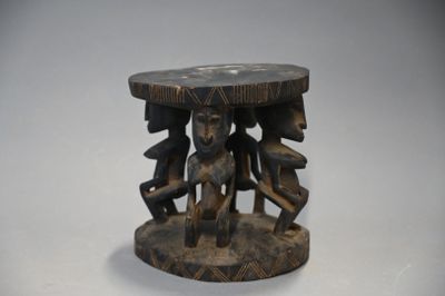 une petite table en bois dont le plateau est orné d'un motif sculpté