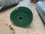 a roll of green grass on the floor next to a pair of scissors