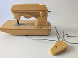 a yellow sewing machine and a mouse on a white surface