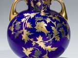 a purple vase with gold leaf designs on it