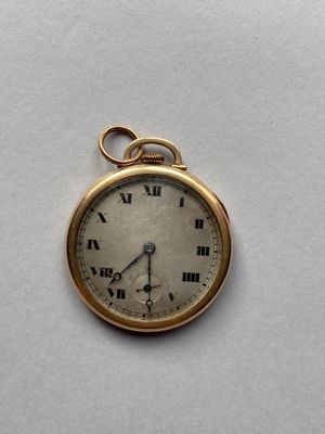 une montre de poche en or avec des chiffres romains