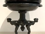 an image of a black bowl on a stand on a table