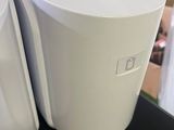 two white trash cans sitting on a table in a store