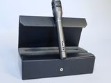 a microphone in a black box on a white surface