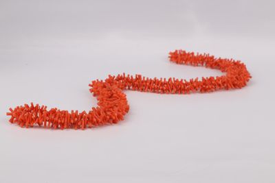 a close up of a pair of orange pipe cleaners on a white surface