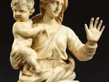 a statue of a woman holding a child and waving