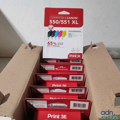Des boîtes de cartouches d'encre sont empilées les unes sur les autres dans un carton.