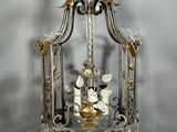 une cage à oiseaux en argent et en or, avec un oiseau à l'intérieur