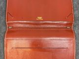 a brown leather wallet on a gray surface
