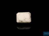 a close up of a white marble block on a black surface