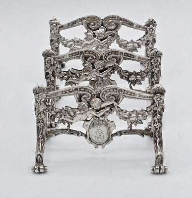 a silver chair that has a clock on the back of it