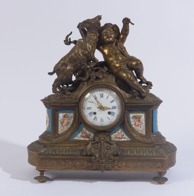 une horloge surmontée d'une statue, posée sur une table
