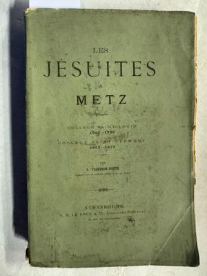 un vieux livre posé sur une table à côté d'un mur blanc