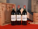 three bottles of wine sitting on a table next to a wooden box