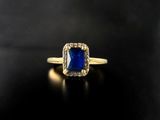 a gold ring with a blue sapphire stone surrounded by diamonds