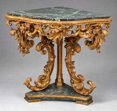 une table richement sculptée, dotée d'un plateau en marbre et ornée de décorations à la feuille d'or