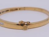 a close up of a gold bracelet with a heart on it