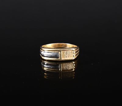 gros plan d'une bague en or sur une surface noire