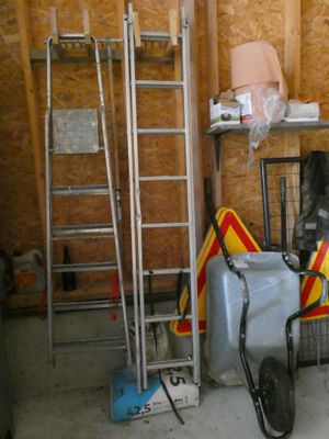 une pièce dans laquelle se trouvent une échelle, une chaise, une valise et d'autres objets