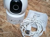 a white camera sitting on top of a table next to a charger