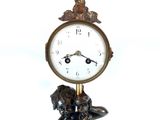 a statue of a woman holding a clock on a table