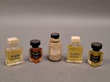 three miniature bottles of perfume sitting next to each other on a table
