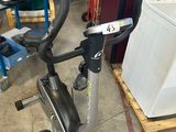 an image of a stationary exercise bike in a garage with a washing machine