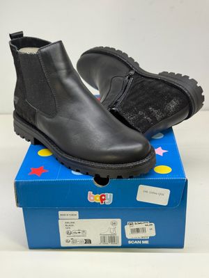 Les bottes noires des enfants sont posées sur une boîte bleue.