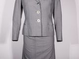 une photo d'un tailleur-jupe gris pour femme sur un mannequin