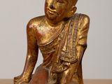 statue of a person sitting on the ground with his legs crossed