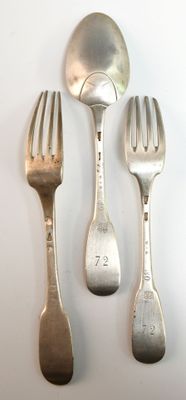 trois fourchettes et deux cuillères sur une table blanche