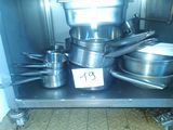 many pots and pans on the shelf in the kitchen