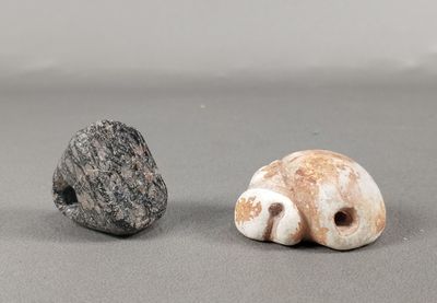 two small rocks sitting next to each other on a table