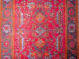 a red and blue rug with a floral design on it