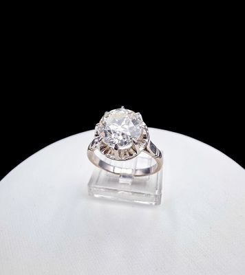 a close up of a diamond ring on a white surface