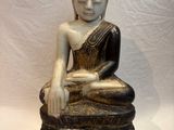 statue d'un Bouddha assis sur un socle en bois, sur fond blanc