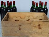 a wooden crate with six bottles of wine in it