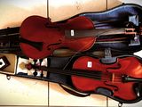 a violin and a violin case sitting on a tile floor