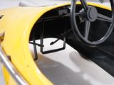 steering wheel and dashboard of a yellow race car in a garage