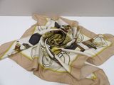 beige and yellow scarf on a white table with a fork and knife