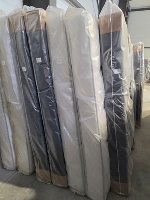 many mattresses wrapped up in plastic in a warehouse
